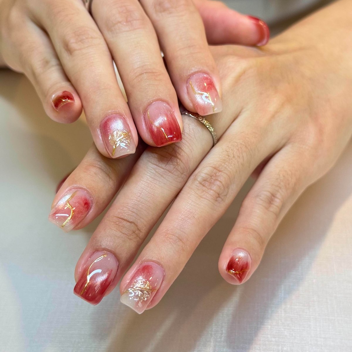 Red watercolour nail art with fine gold detailing