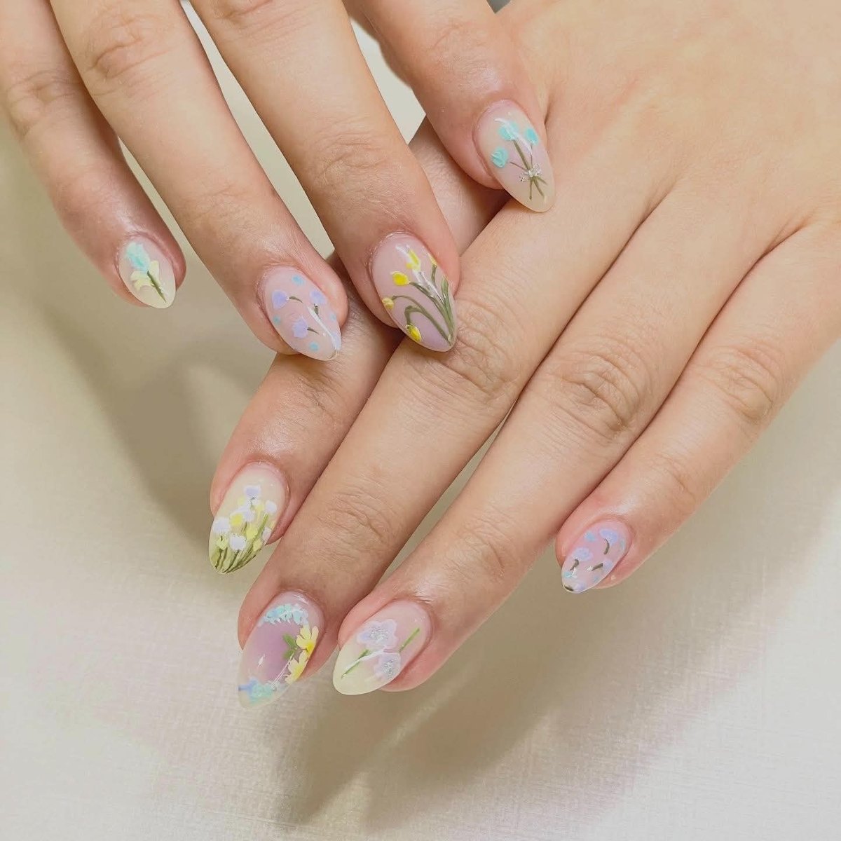 Pastel botanical nail art in soft blue, yellow and lilac