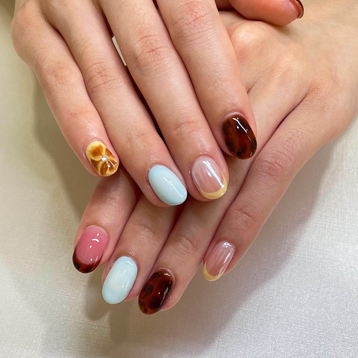 Modern tortoiseshell nails paired with soft pastel accents