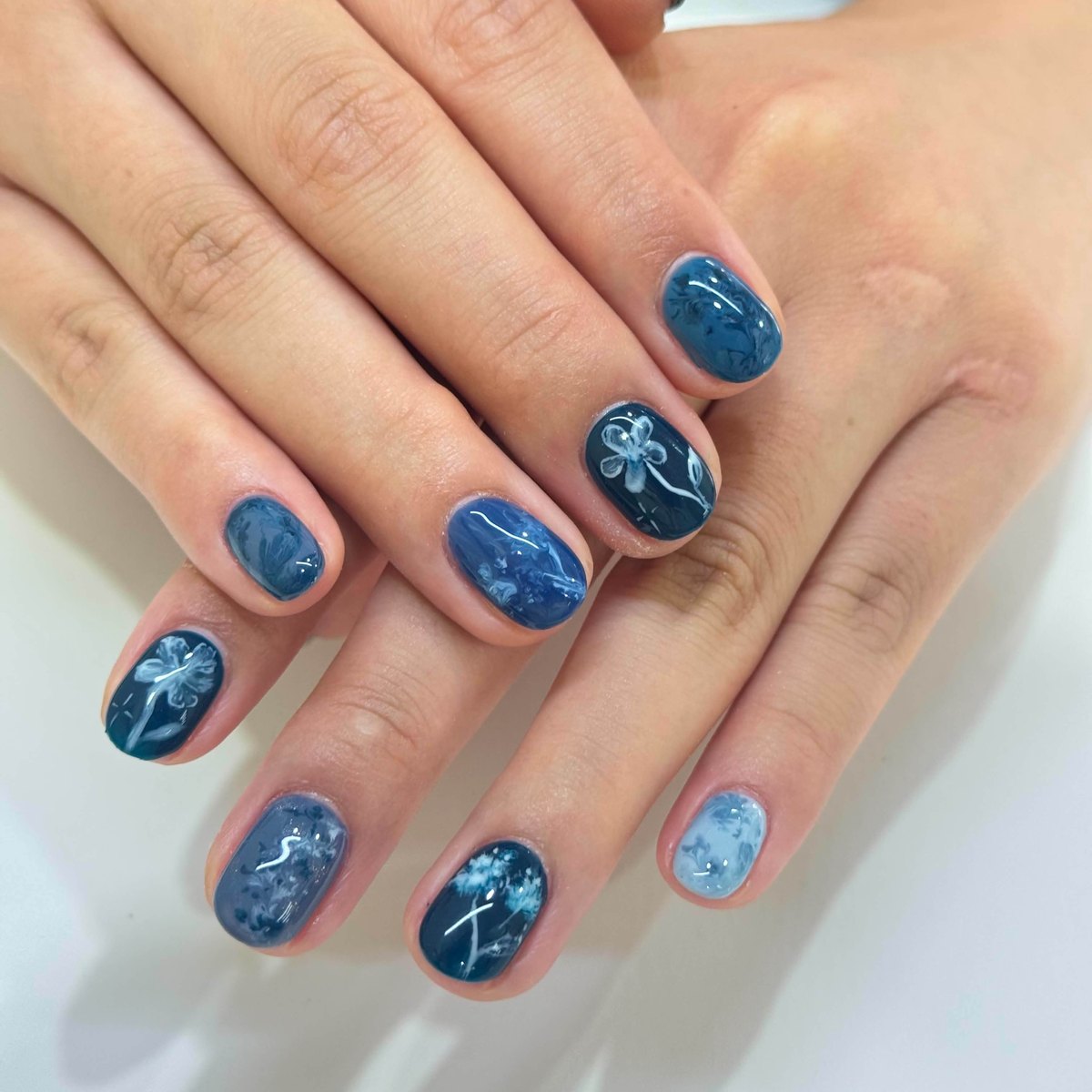 Deep blue marble nail art with hand-painted floral details